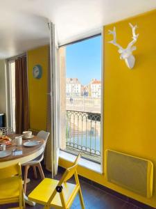 索恩河畔沙隆Le St Laurent - Ma Cabotte的一间带桌子和大窗户的用餐室