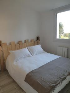 多吕多勒龙la belle cascade的卧室内的一张白色床和木制床头板