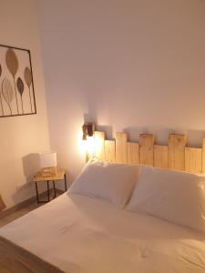多吕多勒龙la belle cascade的卧室配有白色的床和木制床头板