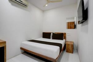 孟买OYO Hotel Vrindavan Residency的一间小卧室,配有一张床和电视