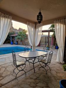 ElmaDar Farah的一个带桌椅的庭院和一个游泳池