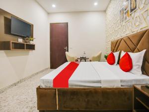 卢迪亚纳Super OYO Silver Sky的一间卧室配有一张带红色枕头的大床