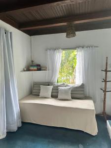 塞古罗港Chales do Oliveira的一间卧室设有一张大床和窗户