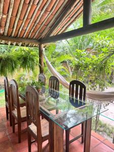 塞古罗港Chales do Oliveira的一个带吊床的庭院里的玻璃桌子和椅子