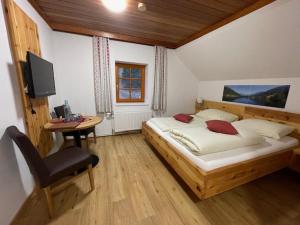 滨湖费尔德图尔奈霍夫宾馆的一间卧室配有一张床、一张书桌和一台电视