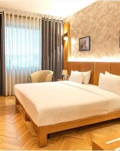 地拉那地拉那国际酒店及会议中心的一间卧室设有一张大床和一个窗户。