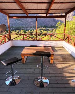 科金博Hostal Al Yaras的一个带木桌和两个凳子的庭院