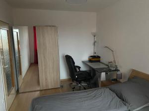 埃朗根Helle 2-Zimmer Wohnung Erlangen的一间卧室配有书桌、床、书桌和椅子