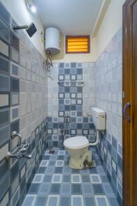 蓬蒂切里Le Mission Stay的浴室设有卫生间,铺有蓝色和白色瓷砖。