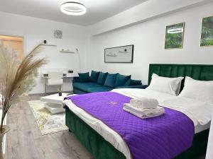 布拉索夫Coresi Mall Area Studios & Apartments by GLAM的一间卧室配有一张床和一张蓝色的沙发
