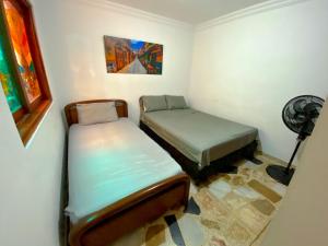麦德林Casa EstadioMed的小型客房配有2张床和风扇。