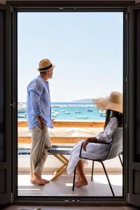 帕罗斯岛KIANO SUITES的站在海滩的窗户上的男人和女人