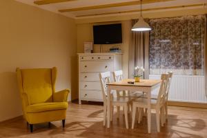 马汀图列茨德沃尔公寓的一间带桌子和黄色椅子的用餐室