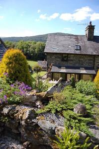 多尔盖罗Tre-Allt Gorgeous Cottage的石头房子前面的花园