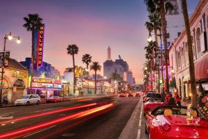 洛杉矶Los Angeles Premium 2BR&2BT Suites with Free Parking的夜间有汽车和棕榈树的城市街道