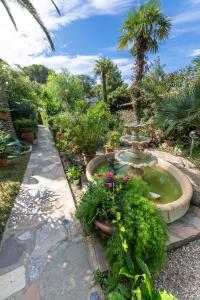 卡波利韦里***Villa Prestige****的花园,花园内拥有植物和鲜花的喷泉
