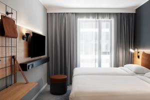 米尔顿凯恩斯Moxy Milton Keynes的酒店客房设有两张床和电视。