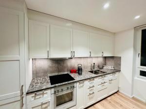 乌斯特Exclusive apartment for families and business的厨房配有白色橱柜和台面
