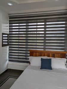 PrampramKabeya Place的一间卧室配有一张带蓝色枕头的大床