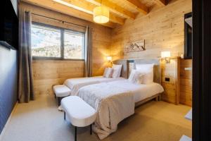 圣费朗索瓦-隆尚Chalet Le Bouquetin的小木屋内一间卧室,配有两张床
