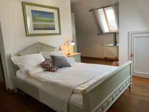 博尔纳Hotel zur Schlossmühle的卧室配有一张带白色床单和枕头的大床。