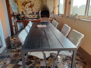 洛帕Apartments Rajka的餐桌、白色椅子和壁炉