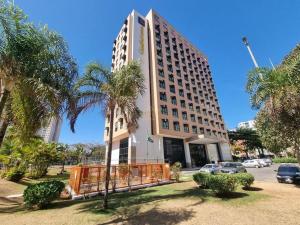 巴西利亚Flat 609 - Comfort Hotel Taguatinga的一座棕榈树环绕的大建筑