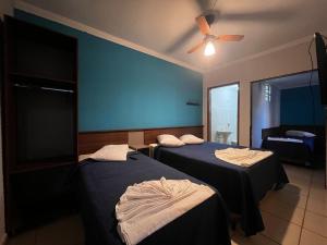 阿帕雷西达Hotel Cesar Nogueira的客房设有两张床和吊扇。