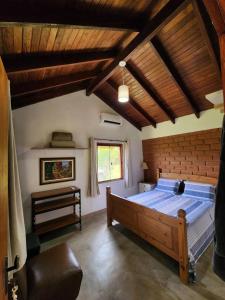 戈亚斯州上帕莱索Refúgio Tao Cerrado Chalé Pé de Serra的一间卧室设有一张大床和木制天花板