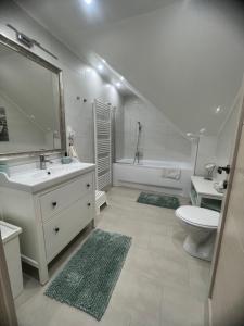 凯斯特海伊Galéria Apartmanház的白色的浴室设有水槽和卫生间。