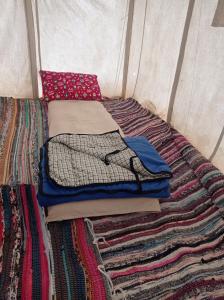 Dār as Salāmflamingo camp的帐篷内床上的一堆衣服
