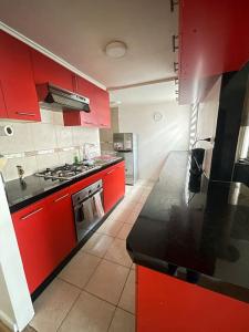 蒙特港Casa en Puerto Montt的厨房配有红色橱柜和黑色台面