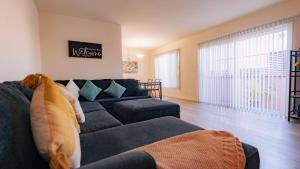 长滩Long Beach Cozy Remodled Home的客厅设有蓝色的沙发和大窗户