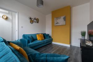 科尔切斯特Sunbeam cottage contractor Parking WiFi Garden的客厅设有蓝色的沙发和黄色的墙壁