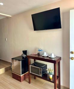 恩塞纳达港Casa Berty 4的客房设有微波炉和带电视的桌子。