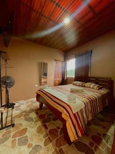 迦太基Dreams Lodge Orosi的一间卧室设有一张带木制天花板的大床