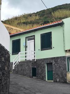 奥尔塔Mar Rosa - Terraço Vista Praia的绿色白色的房子,设有白色阳台