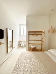 莱乌卡Camere Assúd的白色卧室配有床和镜子