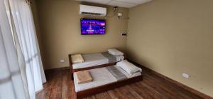 玛利亚镇Casaquinta的客房设有两张床和一台墙上的电视。