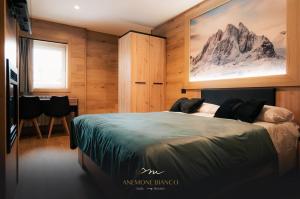 帕苏德尔托纳莱Anemone Bianco Suite Rooms的卧室配有一张床,享有山脉美景
