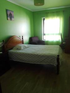贝雅Casa Modesta II的绿色卧室配有床和椅子