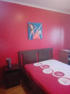 贝雅Casa Modesta II的卧室配有一张红色的床,墙上挂着一张照片