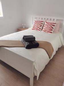 马德里Villa con patio的卧室配有带枕头的白色床