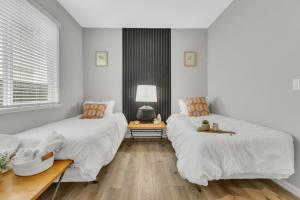 西萨克拉门托Modern-fully Loaded-ev Charger-big Yard-10 Min Dt的配有白色墙壁和木地板的客房内的两张床