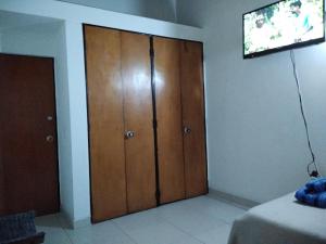 波哥大Hostal Norma101的客房设有木制衣柜和电视。