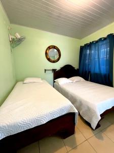 GuayabalMiravalles Volcano House的配有两张床铺的蓝色窗帘和镜子