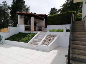 查韦斯Casa da Encosta Chaves的一座带花园的房子,前面设有楼梯