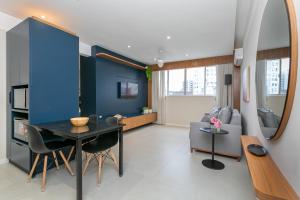 弗洛里亚诺波利斯Confortável Studio com 46,72m²的客厅配有桌子和蓝色的墙壁