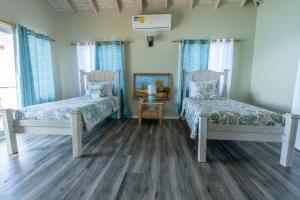 Crab HillThe Ti-Kaye Oasis的一间卧室配有两张床和镜子