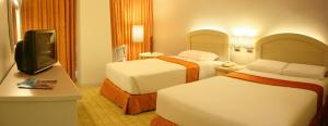 马尼拉海滨大厦酒店的酒店客房设有两张床和一台平面电视。